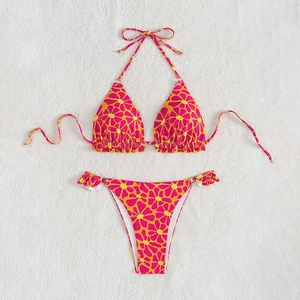 Detailed flat lay of floral print bikini with vibrant pink and orange tropical pattern