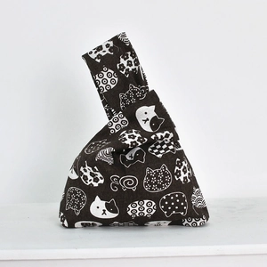 Detailed close-up of dark brown linen wrist bag with white cat patterns in Japanese style