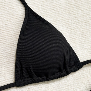Close-up of black ribbed knit bikini top showing fabric texture and triangle cup design
