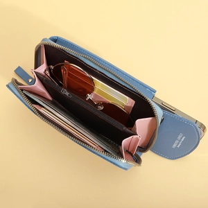 Blue multi-functional crossbody phone bag and wallet with interior card slots on yellow background