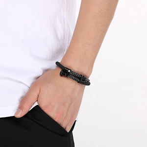 Detail view of men's black stainless steel nail bracelet with braided leather band