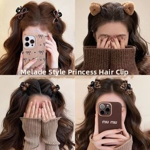 Detail of four brown mini hair claws in plush, leopard print, and ribbon styles
