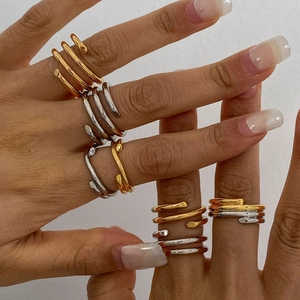 Stacked gold and silver stainless steel spiral rings worn on finger with twisted multi-layer