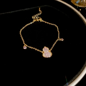 Close-up of 18k gold plated gourd bracelet with purple zircon inlay on black velvet
