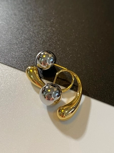 Detailed macro view of French vintage dual-tone water drop earrings with metallic spheres