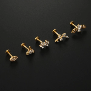 Detailed view of five gold-plated titanium labret studs with zircon inlays on black