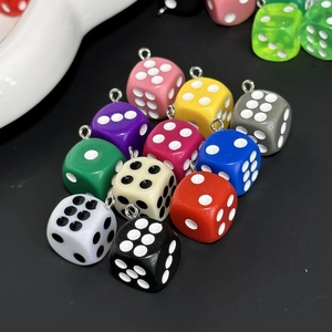 Close-up of colorful resin dice charms with silver metal rings for DIY jewelry