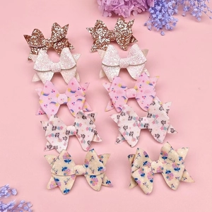 Set of 10 glitter sequin bow hair clips for kids on a pastel pink background