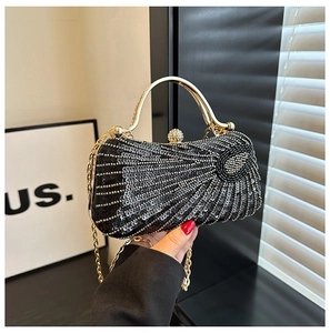 Detail of black sequined evening clutch bag with gold handle and sparkling bead patterns