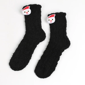 Detail von flauschigen schwarzen Korallenfleece-Socken mit süßer Weihnachtsmann-Puppe