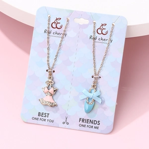 Dettaglio collane Best Friends con ciondoli abito rosa e scarpetta da danza blu