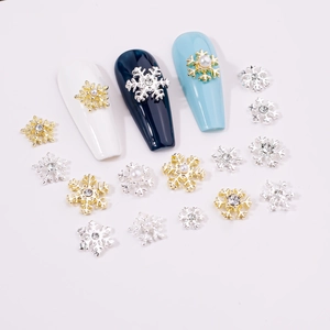 Macro shot of gold and silver alloy snowflake nail charms with pearls and rhinestones