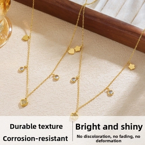 Detail of gold-plated necklaces with heart and flower charms and sparkling zircons