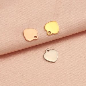 Polished heart shaped pendants in rose gold, gold, and silver on silk fabric