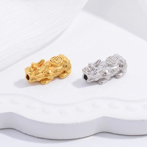 Macro shot of gold and silver plated S925 sterling silver PiXiu charms for DIY jewelry