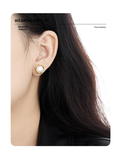 Detail of S925 silver flower pearl earrings with crystals worn on a model's ear
