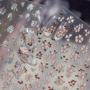 Detail of 3D embossed floral nail stickers with gold edges and pink cherry blossoms