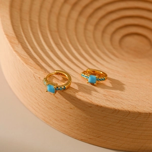 Vintage 18K gold plated brass hoop earrings with turquoise stones on a wooden stand