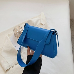 Detail showing high-quality blue PU leather shoulder bag with wide strap and minimalist style