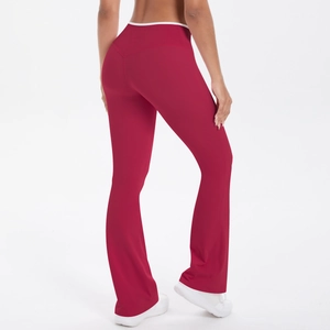Detail view of high waist burgundy yoga flare pants with white contrast waistband and split hem