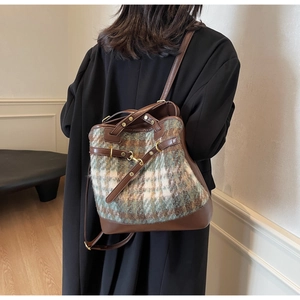 Detail of vintage plaid bucket bag with leather drawstring and textured fabric texture