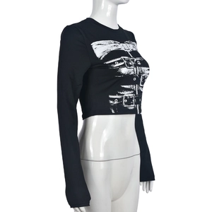Detail of black cropped long sleeve top featuring white belt buckle graphic print