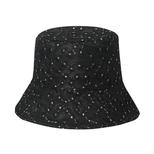 Detail showing white star pattern on black quilted cotton fisherman sun hat surface