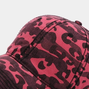 Macro shot of red and black leopard print baseball cap fabric with detailed stitching