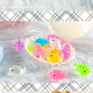 Close-up of colorful resin dolphin mini ornaments scattered in a white shell
