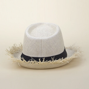 Détail d'un chapeau de paille Fedora avec bords effilochés et ruban décoratif noir