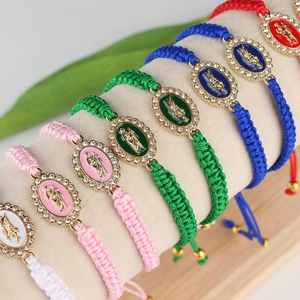 Detail of colorful woven religious bracelets with rhinestone virgin Mary charms