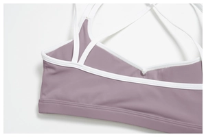 Detail of cross-back straps and white piping on lavender high-stretch sports bra
