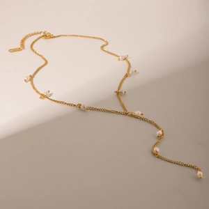 Detail view of 18K gold stainless steel Y-necklace with small white pearls on dual background