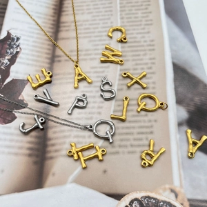 Antike 18K Gold und Silber Buchstabenanhänger auf Buchseiten mit feinen Halsketten