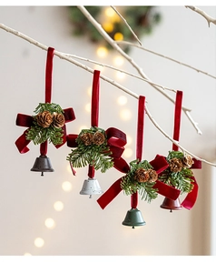 Detail von Weihnachtsglocken aus Samt mit Tannenzapfen und Nadeln an weißen Zweigen