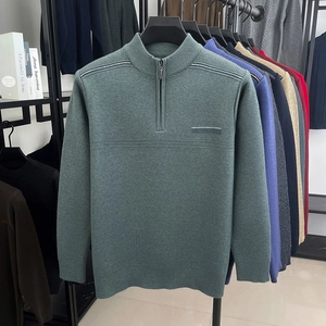 Detail of dark green knit sweater featuring a half-zip stand collar and textured fabric