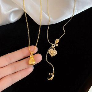 Detailed close-up of golden lucky bag and celestial heart pendants with zircon inlay