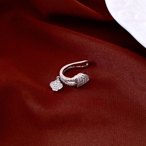 Detailed close-up of a silver swan ear cuff with sparkling zircons on red velvet