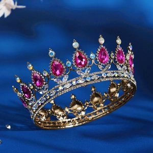 Golden baroque bridal crown with pink gemstones and crystals on blue silk background