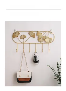 Close-up of golden metal ginkgo leaf wall hooks for entryway organization and decor