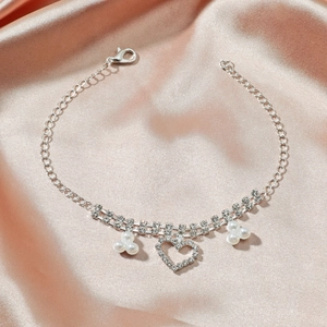 Détail de la chevillère argentée avec pendentif coeur en cristal et perles blanches