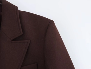 Detail des schokobraunen Blazers mit hochwertigem Webstoff und Reverskragen-Detail