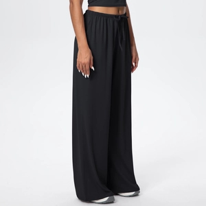 Detail of high-waist drawstring waistband on black wide-leg trousers with flowy fabric