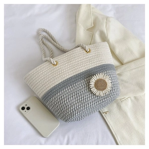 Detail of woven tote bag with 3D daisy flower decoration and rope handles
