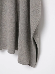 Vue détaillée du tissu en maille grise montrant la texture et le drapé de la jupe midi