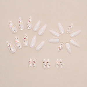 Almond-shaped press-on nails with cherry blossom patterns and gold foil on creamy white base