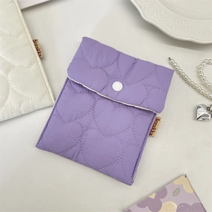 Close-up of heart-quilted sanitary pouch with snap closure and side brand label