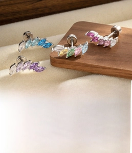 Macro detail of marquis zircon ear studs in gradient colors with titanium steel posts
