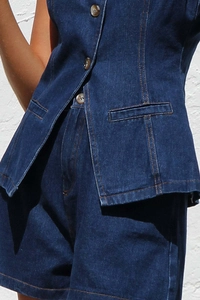 Détails du tissu denim bleu foncé avec coutures orange et boutons en bronze massif