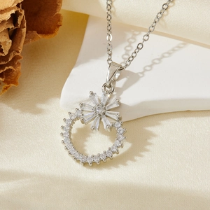 Détail macro du pendentif fleur en argent avec zircons étincelants sur une chaîne fine